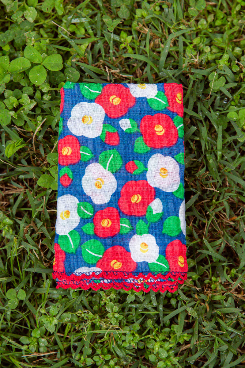 Kin Ship Goods camellia flower bandana with red, white, and green blooms on navy—cotton-poly blend for everyday floral flair.