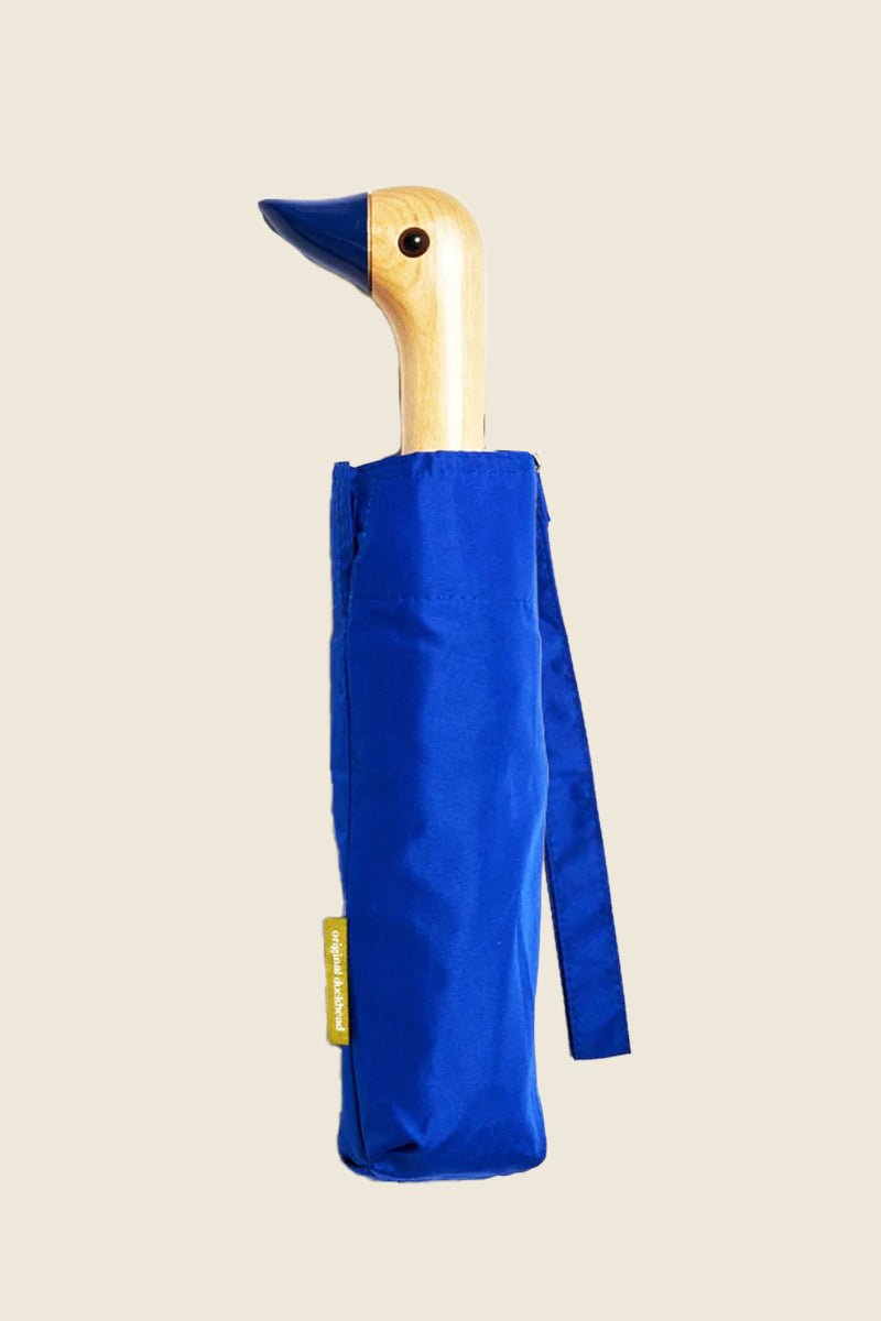 Kin Ship Goods royal blue umbrella with wooden duck handle and matching blue beak—fun, compact, and practical rainy day essential.