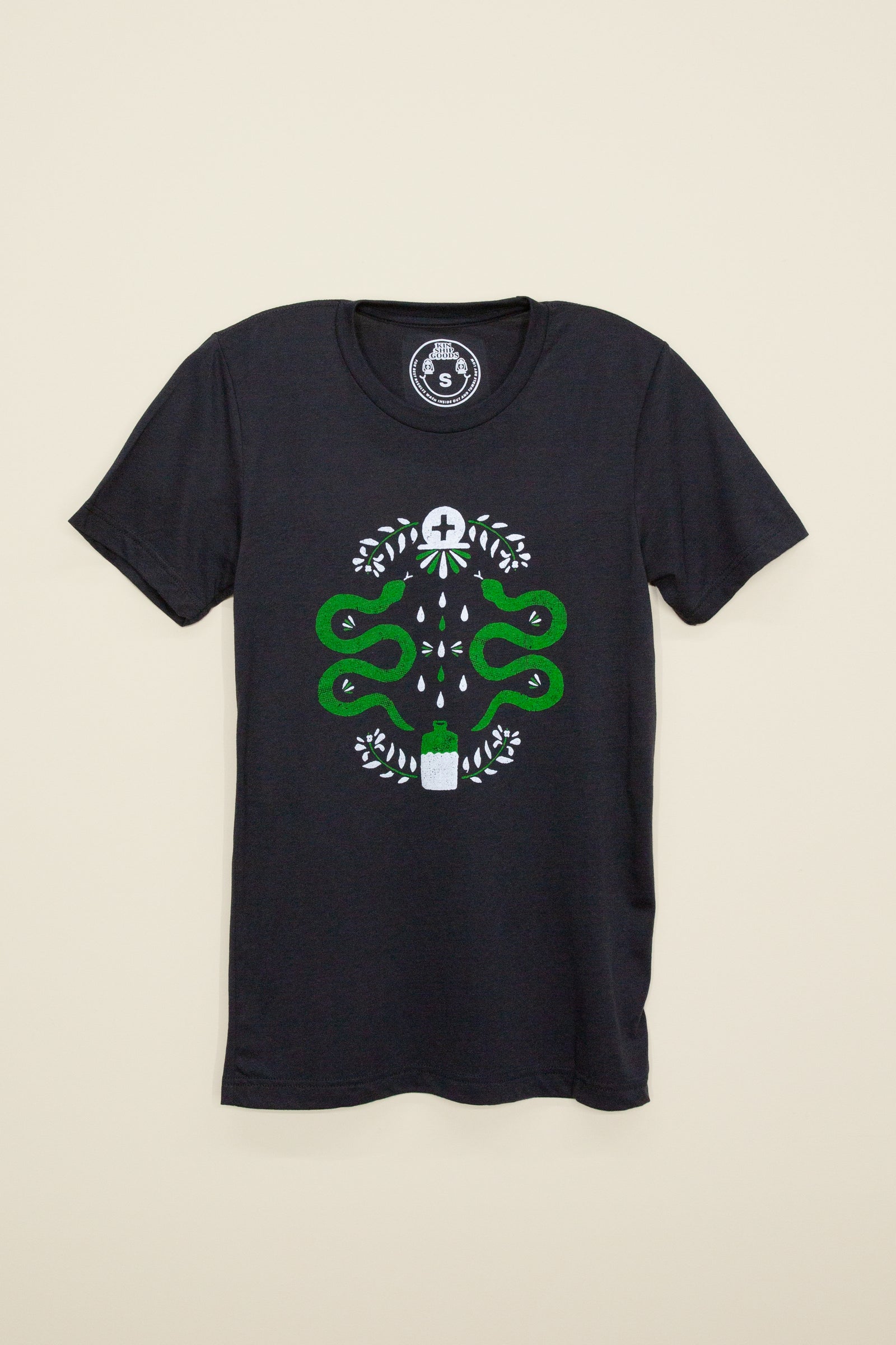 Kin Ship Goods black tee with modern hex sign design featuring green snakes, leaves, and potion bottle—symbolizing protection, strength, and healing.