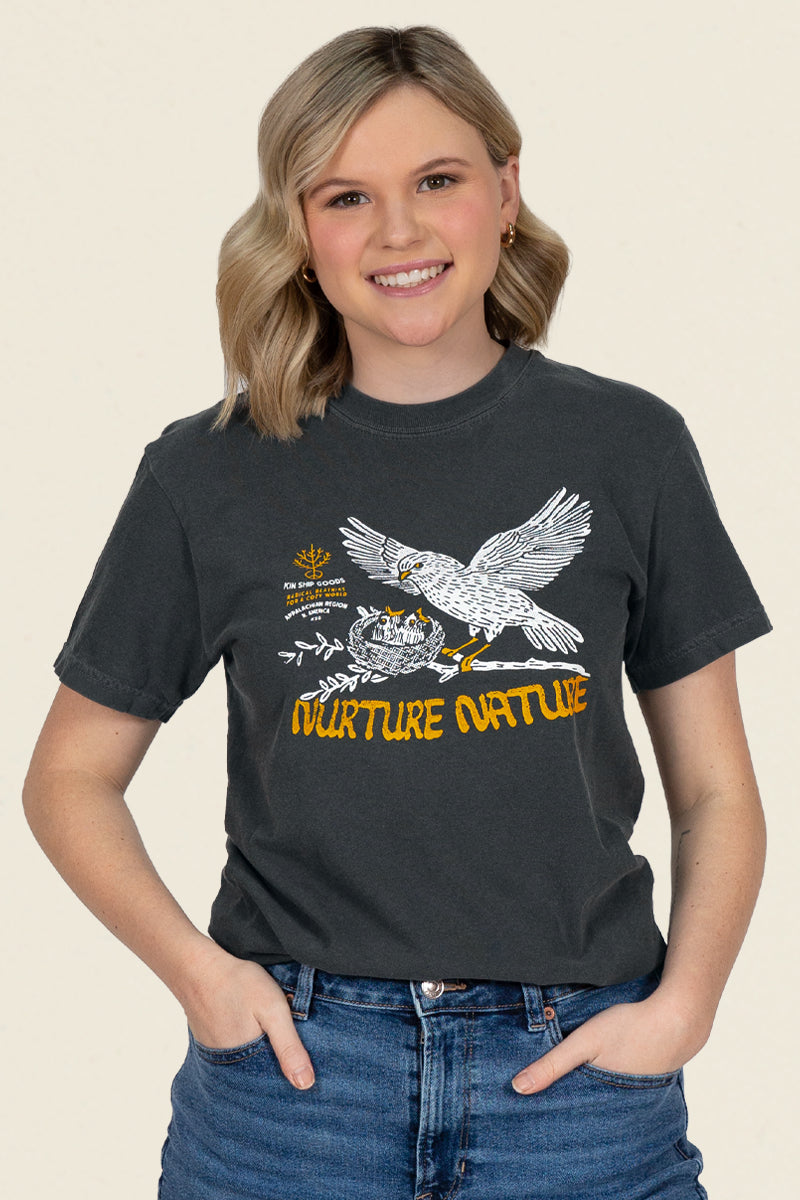 Kin Ship Goods black t-shirt with bird feeding chicks in a nest and 'Nurture Nature' message in golden yellow.