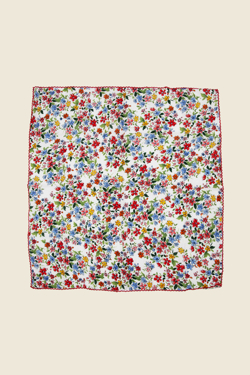 Kin Ship Goods: White bandana with red, blue, and yellow floral print and scalloped edge.
