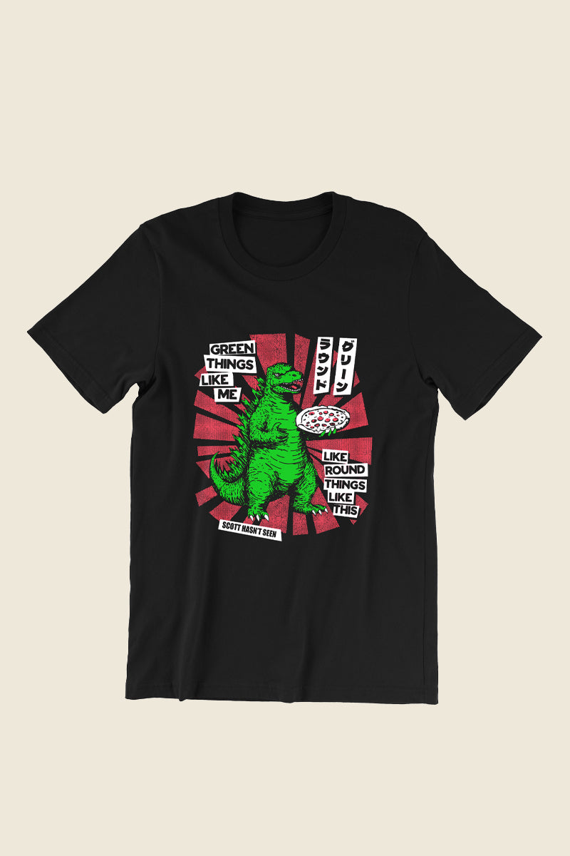 Kin Ship Goods x Comedy Bang Bang tee featuring a green dinosaur holding a pizza with comic-style text: "Green things like me like round things like this.