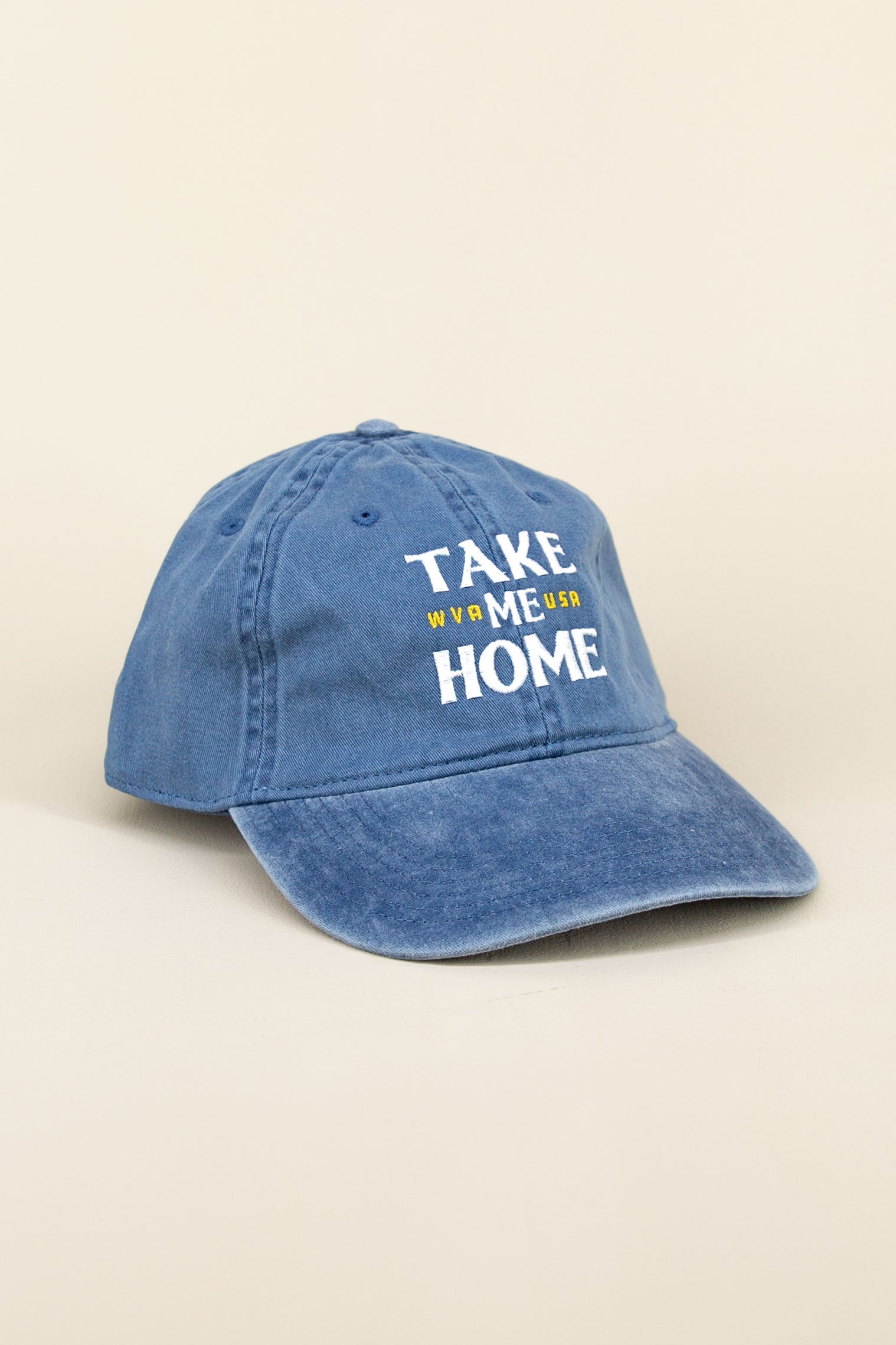 Faded blue Kin Ship Goods baseball cap with white and yellow ‘Take Me Home WVA USA’ embroidery, angled on neutral background.