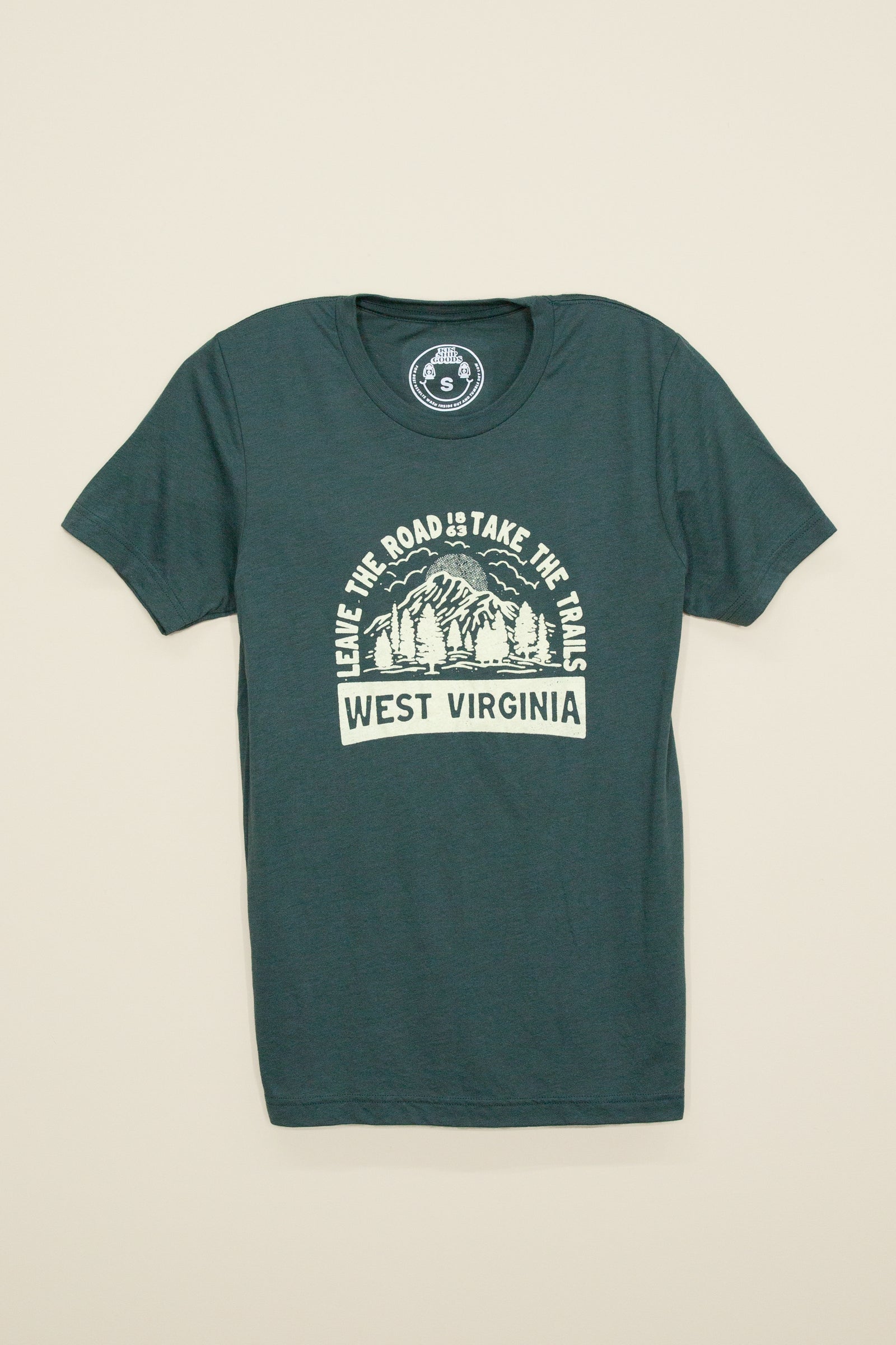 Kin Ship Goods forest green tee with mountain graphic and ‘Leave the Road, Take the Trails – West Virginia’ slogan in cream ink.