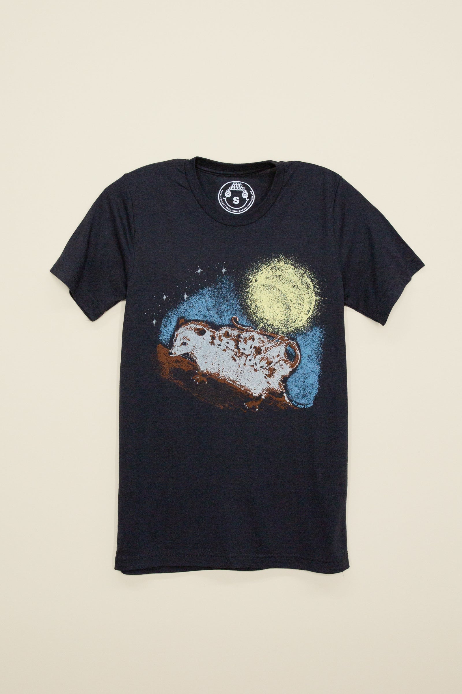 Kin Ship Goods black tee with illustrated opossum family under a glowing moon, known as the ‘Trash Family’ design.